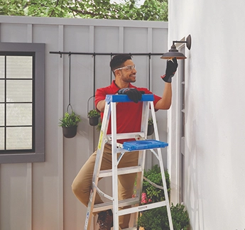 outdoor electrician servicing light fixture