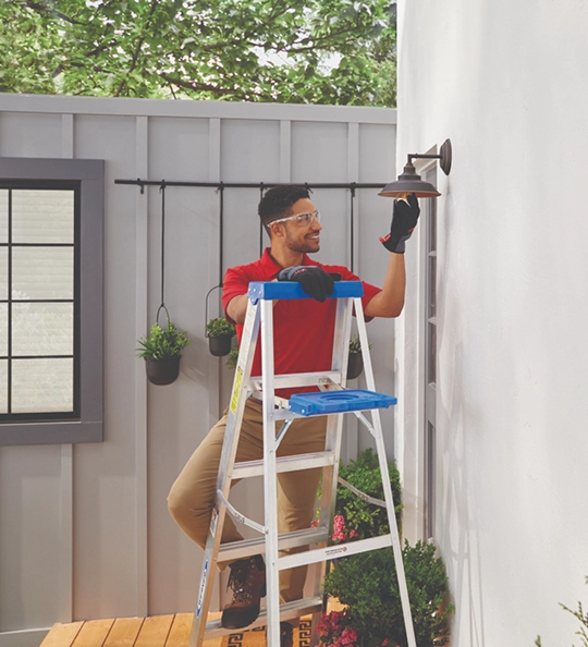 outdoor electrician servicing light fixture