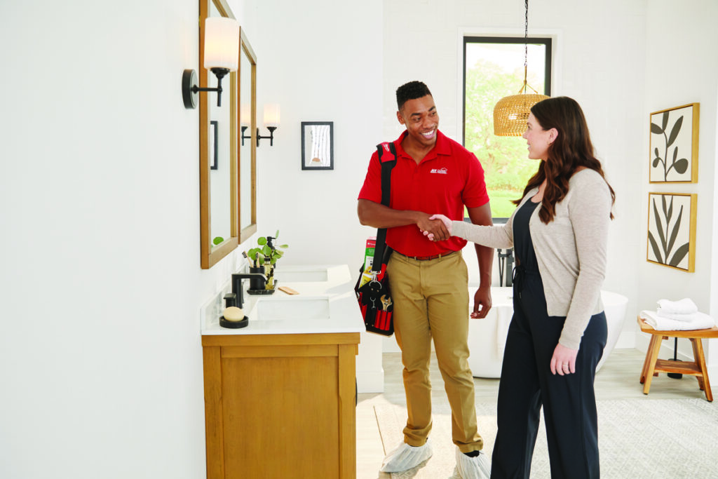 Plumber shaking hands with a homeowner in bathroom