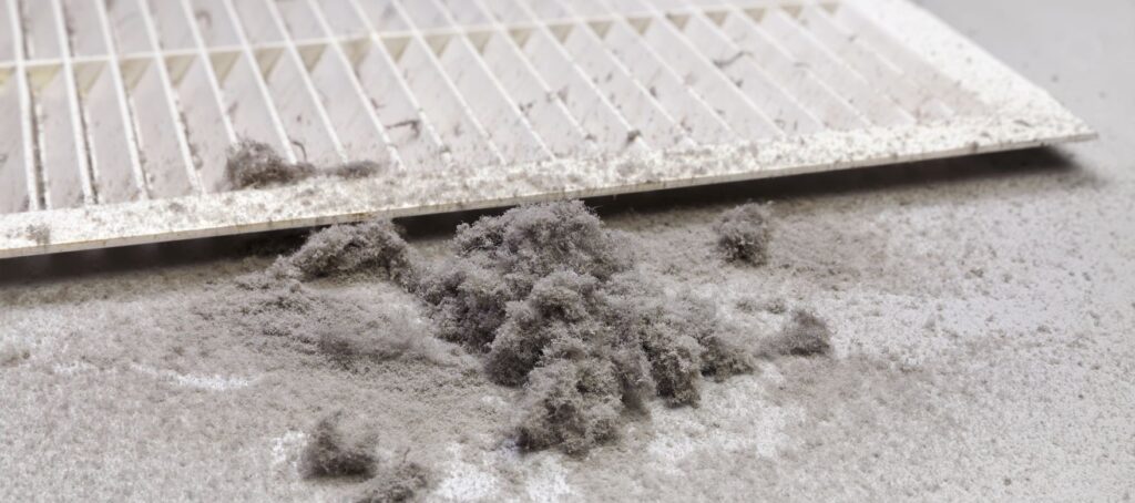 Pile of dust next to an HVAC register vent